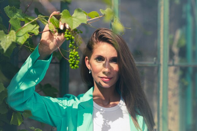 Portrait of young woman standing against plants