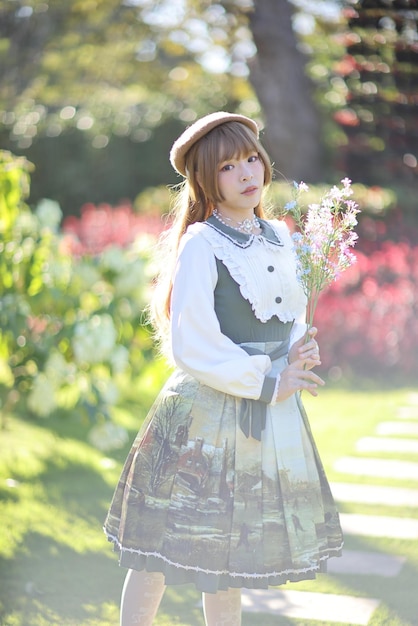 植物に寄りかかって立っている若い女性の肖像画