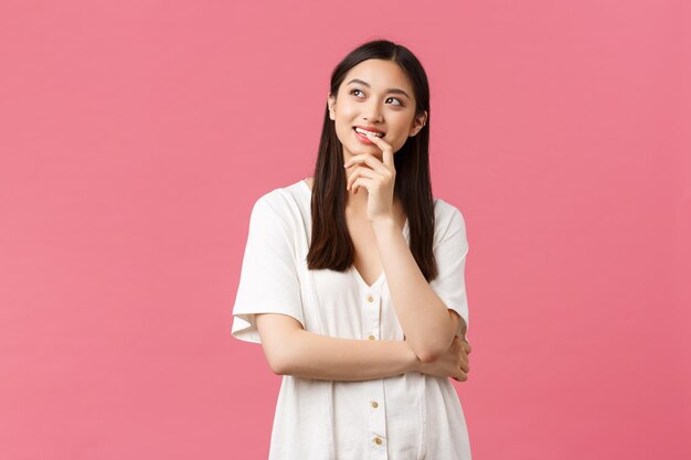 Portrait of young woman standing against red background