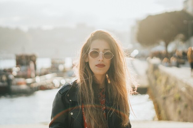 Photo portrait of young woman standing against river and sky