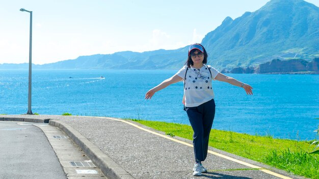 Portrait of young woman standing against sea