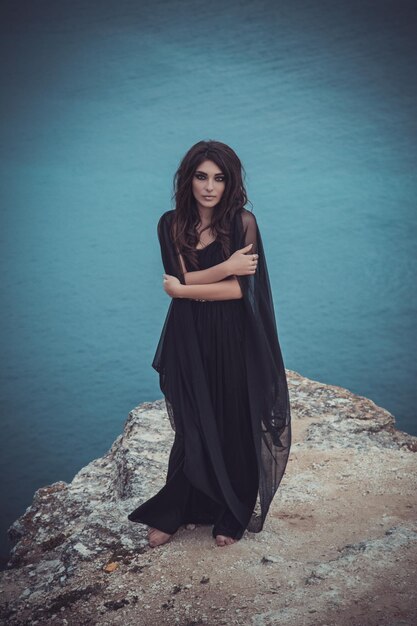 Portrait of young woman standing against sea