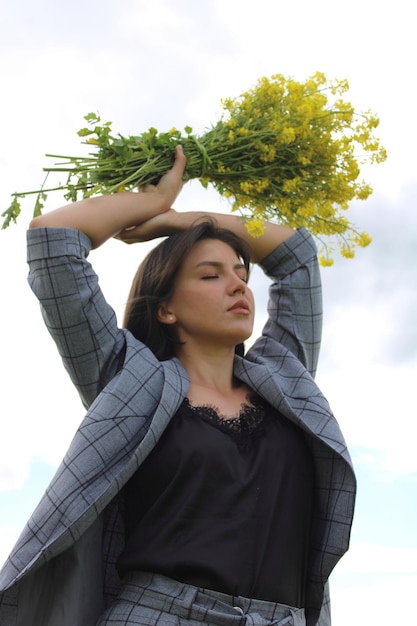 Portrait of young woman standing against sky