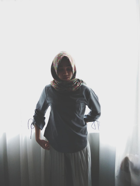 portrait of young woman standing against sky