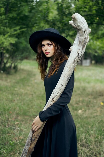 Photo portrait of young woman standing against tree trunk