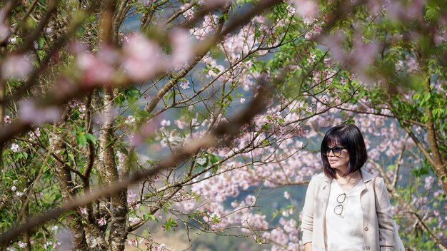 Photo portrait of young woman standing against tree