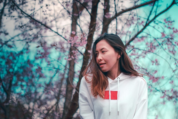 Photo portrait of young woman standing against tree