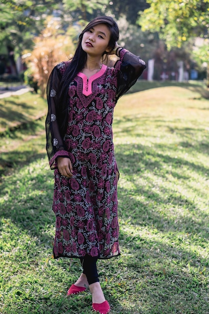 Photo portrait of young woman standing against trees at park