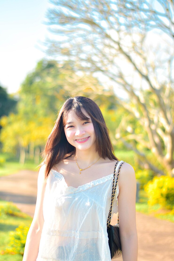 Photo 木に寄りかかって立っている若い女性の肖像画