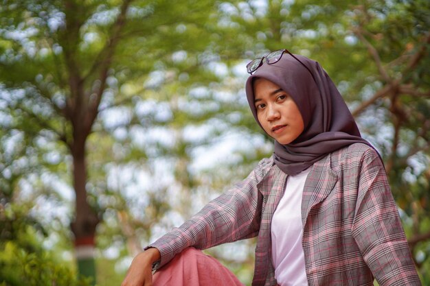 Portrait of young woman standing against trees