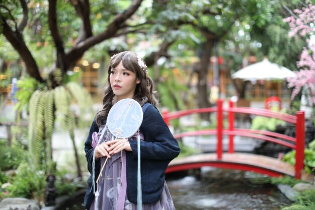 Portrait of young woman standing against trees