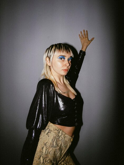 Portrait of young woman standing against wall