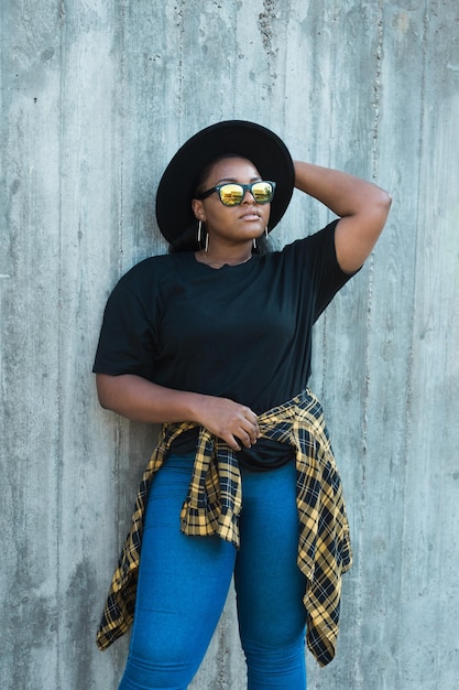 Portrait of young woman standing against wall