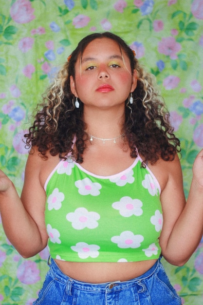 Portrait of young woman standing against wall