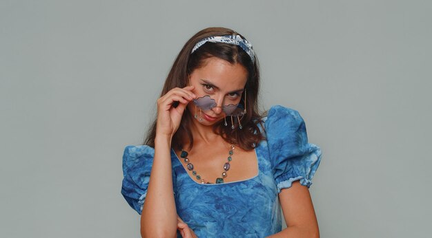 Portrait of young woman standing against wall