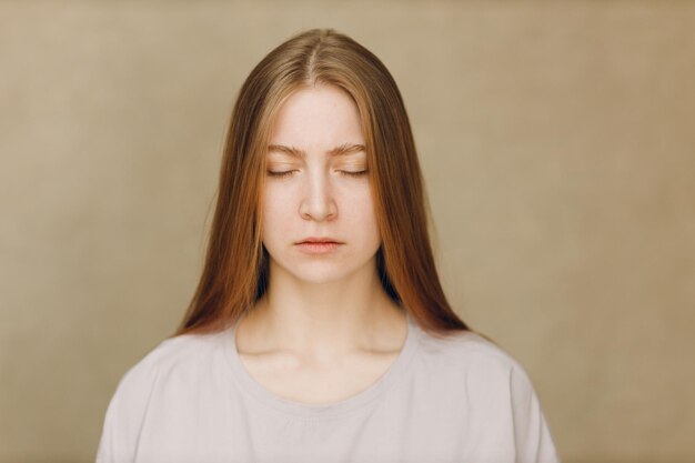 Portrait of young woman standing against wall