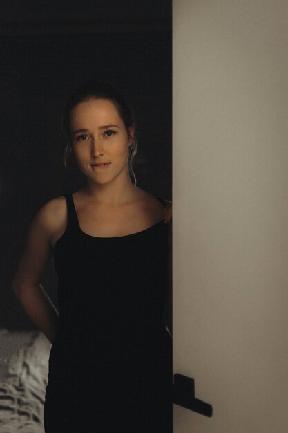 Portrait of young woman standing against wall