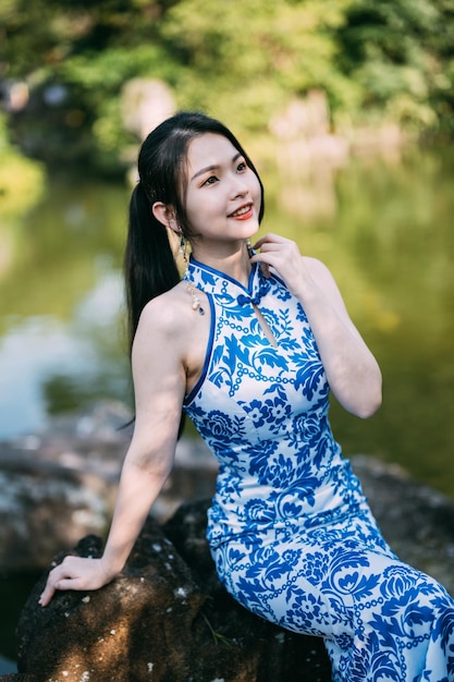 Portrait of young woman standing against waterfall