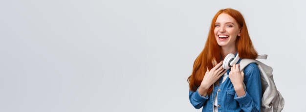 Portrait of young woman standing against white background