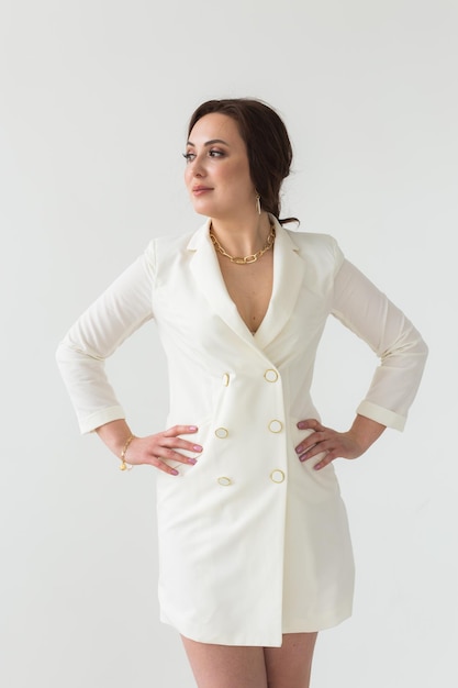 Portrait of young woman standing against white background