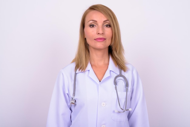 Portrait of young woman standing against white background