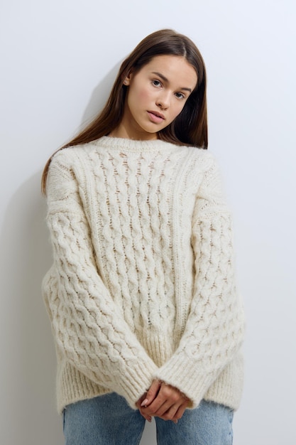 Portrait of young woman standing against white background