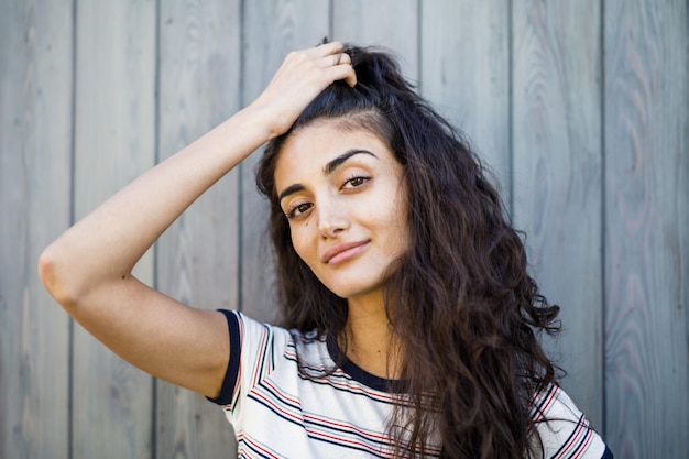 Photo portrait of young woman standing against wooden wall