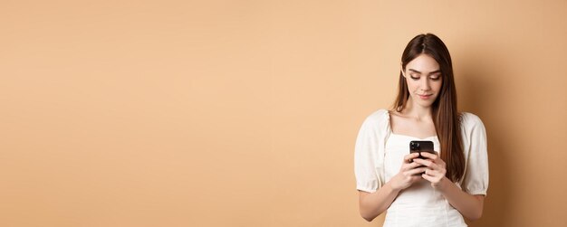 Photo portrait of young woman standing against yellow background