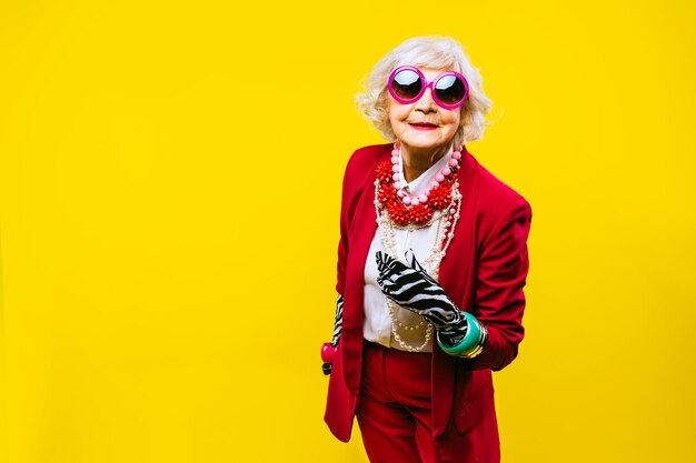 Portrait of young woman standing against yellow background