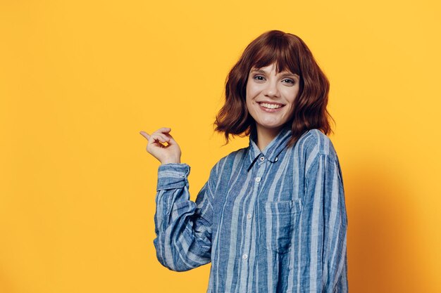 Portrait of young woman standing against yellow background