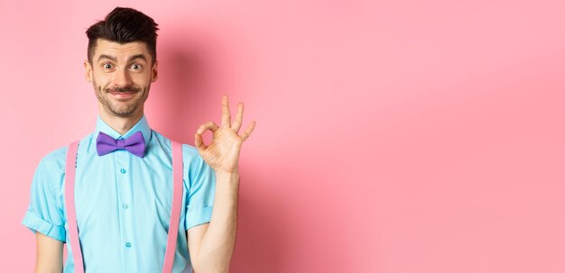 Portrait of young woman standing against yellow background