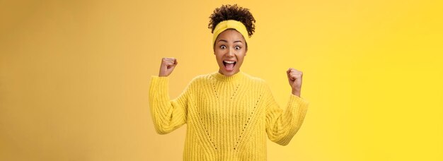 Photo portrait of young woman standing against yellow background