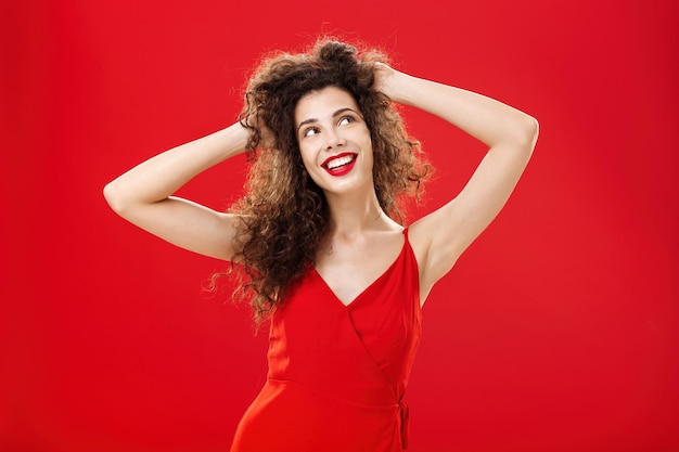 Portrait of young woman standing against yellow background