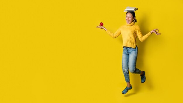 Portrait of young woman standing against yellow background