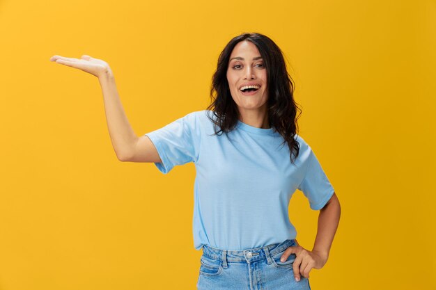 Portrait of young woman standing against yellow background