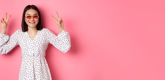 Photo portrait of young woman standing against yellow background