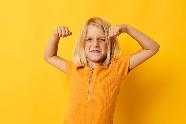 Portrait of young woman standing against yellow background