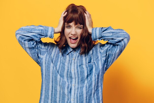 Portrait of young woman standing against yellow background