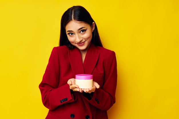 Portrait of young woman standing against yellow background