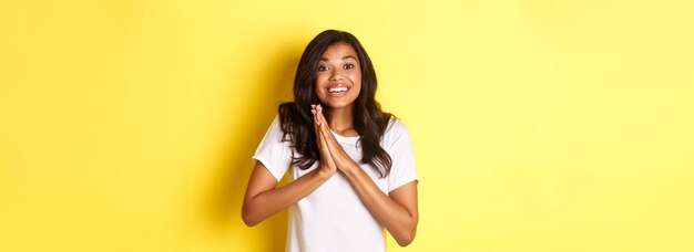 Photo portrait of young woman standing against yellow background