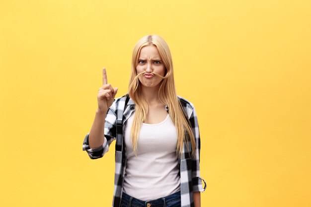 Portrait of young woman standing against yellow background