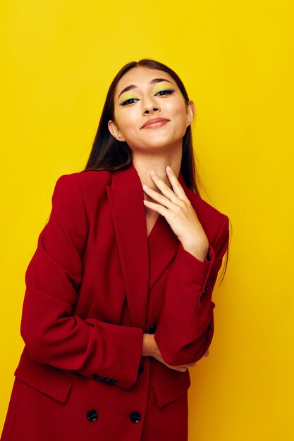 Portrait of young woman standing against yellow background