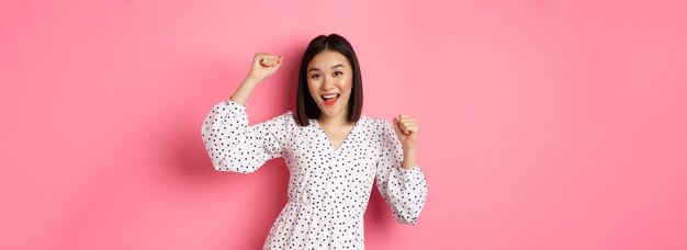 Photo portrait of young woman standing against yellow background