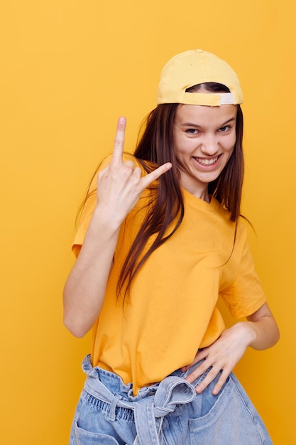 Foto ritratto di una giovane donna in piedi su uno sfondo giallo