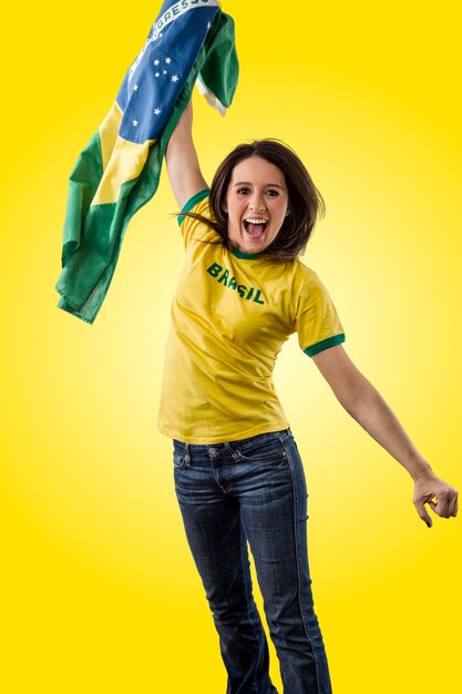 Portrait of young woman standing against yellow background