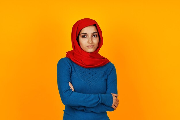 Portrait of young woman standing against yellow background