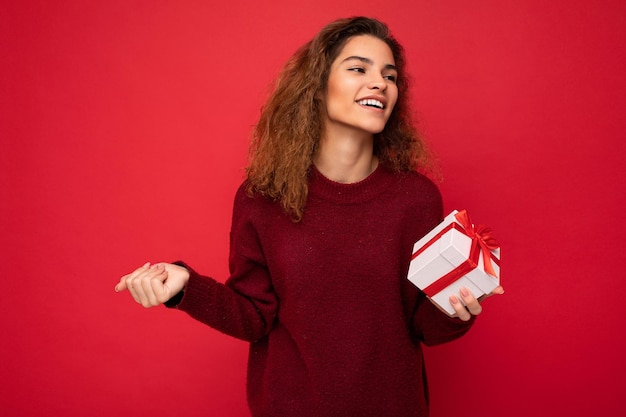 Portrait of young woman standing against yellow background