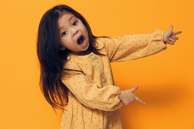 Portrait of young woman standing against yellow background