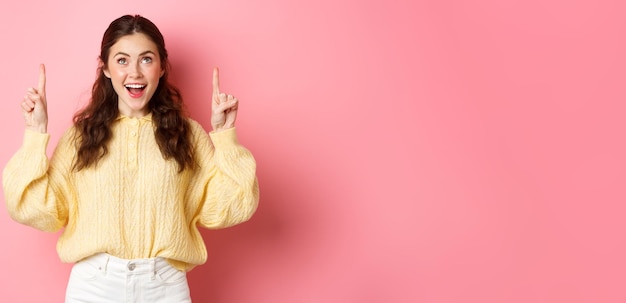 Photo portrait of young woman standing against yellow background