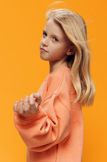 Portrait of young woman standing against yellow background